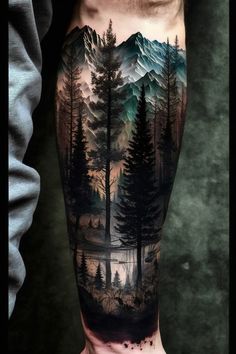 a man's arm with trees and mountains on it