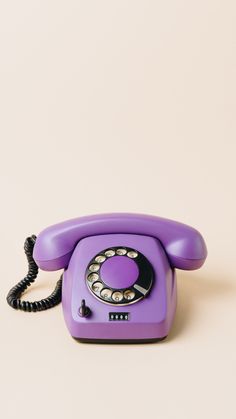 an old fashioned purple phone sitting on top of a table