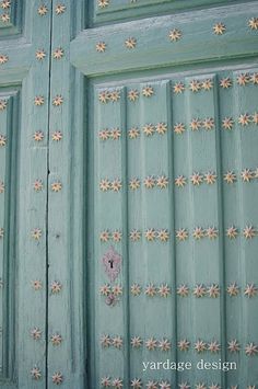 two green doors with flowers painted on them