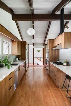 a kitchen with wooden cabinets and white counter tops next to a wood flooring area