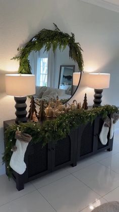 a mirror sitting on top of a table next to a christmas wreath and stockings in front of it