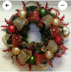 a christmas wreath with red, gold and green ornaments