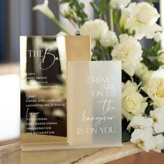 two greeting cards sitting on top of a table next to white flowers and greenery