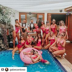 a group of women in pink swimsuits posing for a photo next to a pool