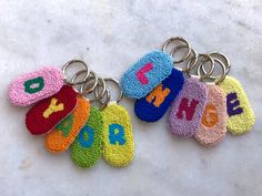 four keychains with different colors and letters on them