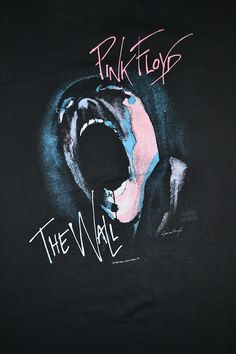 a black shirt with pink floyd's face and the word, the wall on it