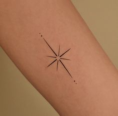 a small star tattoo on the right arm and leg, with dots around it in black ink