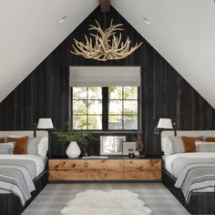 two beds in a room with black walls and white carpeted flooring next to windows