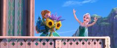 two frozen princesses standing on a balcony with their arms in the air and holding flowers