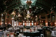 an indoor venue with tables, chairs and chandeliers