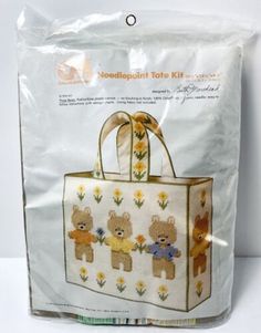 a bag with teddy bears on it and flowers in the front, as well as an ad for needlepoint tote kit