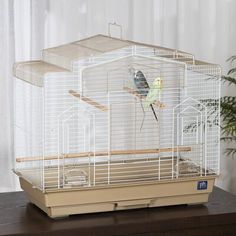 a bird in a cage sitting on top of a table