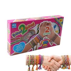 two hands holding each other with bracelets on it's wrist and in front of the box