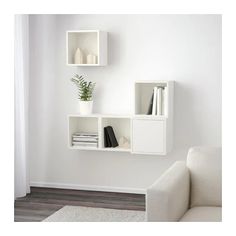 two white shelves with books and plants on them in the corner of a living room