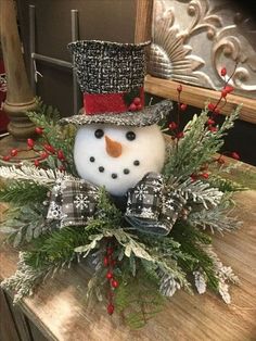 a snowman is sitting on top of a wooden table