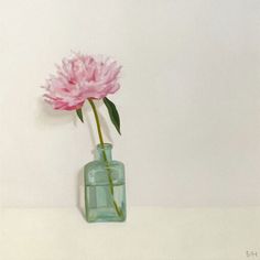 a pink flower in a green glass vase