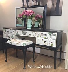 a white desk with flowers on it and a mirror in the corner next to it