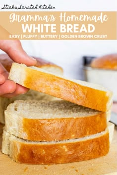 someone is holding a piece of white bread on a cutting board with the rest of it cut in half