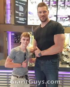 two men standing next to each other in front of a counter