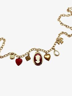 This charm necklace is the perfect mix of classic and trendy... made of mostly vintage charms on a vintage gold-plated chain, we can't even pick our favorite charm! 7 charms hang from this 18" vintage oval-cable chain: tiny brass cat face vintage powder-coated red heart vintage brass dice charm vintage glass/ gold plated cameo charm vintage brass puffy heart clear, natural quartz tear-drop shaped pendant, vermeil (18K gold plated) vintage brass bow Details: 18" in length, but can be clipped to w Elegant Gold-tone Charm Necklace With Vintage Charm, Vintage Metal Necklace With Logo Charm, Vintage Metal Charm Necklace, Vintage Gold-tone Necklace With Logo Charm, Vintage Gold-tone Jewelry For Valentine's Day, Retro Brass Necklaces With Vintage Charm, Vintage Charm Brass Necklace In Retro Style, Vintage Gold-tone Charms For Gifts, Retro Brass Necklace With Vintage Charm