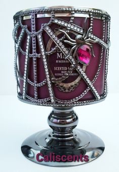 a fancy silver and pink cake on top of a metal stand with an embellishment