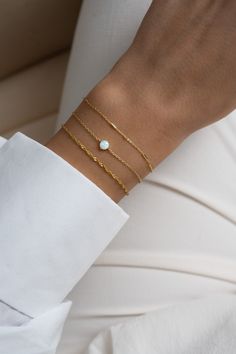 "This solitaire opal bracelet is a sweet and dainty addition to your jewelry collection! It's minimalist design makes it great for stacking, but also looks great on its own! -  -  - D E T A I L S - - - * Made of 925 Sterling Silver * THICK plating of 14k Gold or Rhodium  * 6.25\", 6.75\" , or 7\" + .5\" Ext Lengths available  * Lan created opal stone is made of highest grade of quality for an authentic look! * Nickel-free & Hypoallergenic  * 5mm Opal Stone Bracelets on Model: Turquoise Tennis Bracelet: https://www.etsy.com/listing/1050935357/turquoise-bracelet-turquoise-tennis?click_key=a1a1e3ea13ccfb6cdba3a13472c1aa26c481fdb5%3A1050935357&click_sum=f47583dc&ref=shop_home_feat_2&pro=1 Opal Bracelet: https://www.etsy.com/listing/1063792532/opal-bracelet-white-opal-bracelet?click_key=bc44a7a Dainty Adjustable Opal Bracelet, Minimalist Everyday Opal Jewelry, Minimalist Opal Jewelry With Delicate Chain, Elegant Adjustable Opal Beaded Bracelets, Elegant Opal Beaded Bracelets As Gift, Minimalist White Bracelet With Delicate Chain, White Opal Bracelet, Key Bracelet, Bracelet Tennis