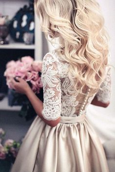 the back of a woman's head with long blonde hair wearing a white dress