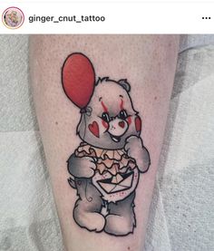 a small tattoo of a bear holding a heart balloon and eating pizza on the leg