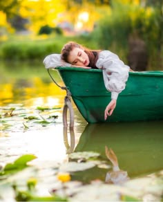 a woman laying down in a green boat