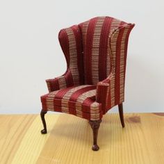 a red striped chair sitting on top of a wooden floor