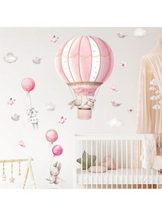 a baby's nursery room with pink and white wall decals, including a hot air balloon