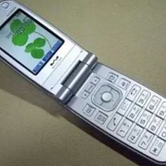 an old cell phone with four leaf clover decals on the front and back sides