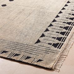 a black and white rug with fringes on it's edges is laying on the floor