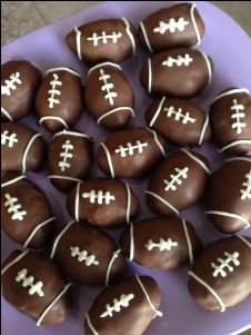 chocolate covered footballs are arranged on a purple plate