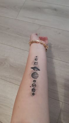 a person's arm with a tattoo on it that has planets drawn on it