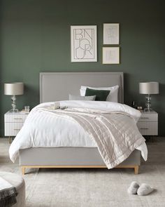 a bedroom with green walls and white bedding