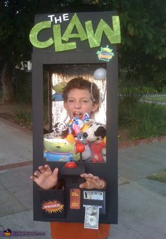 a person standing in front of a claw vending machine with their hands up and mouth open