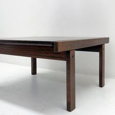 a wooden table sitting on top of a white floor