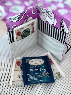 an open wallet sitting on top of a table next to a card holder with money in it