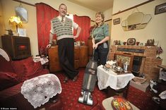 a man and woman standing in a living room next to each other with suitcases on the floor