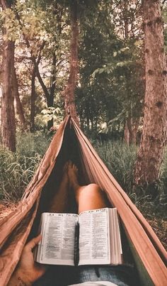 someone is reading a book in a hammock