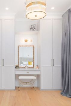 a white dressing room with wooden floors and cabinets