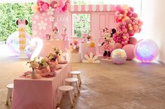 a minnie mouse themed birthday party with balloons, decorations and table cloths on the floor