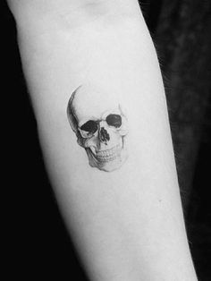 a black and white photo of a skull on the arm