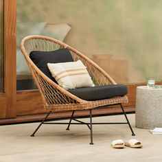 a wicker chair sitting next to a glass door