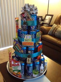 a birthday cake made out of soda cans and candy bar wrappers on a coffee table