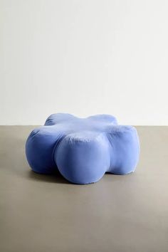 a blue pillow sitting on top of a table next to a white wall and floor