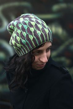 a man wearing a green and black knitted hat