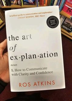 the art of explanation by rostakin's is in front of bookshelves