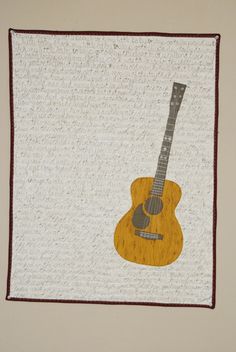 a quilted wall hanging with a guitar on it